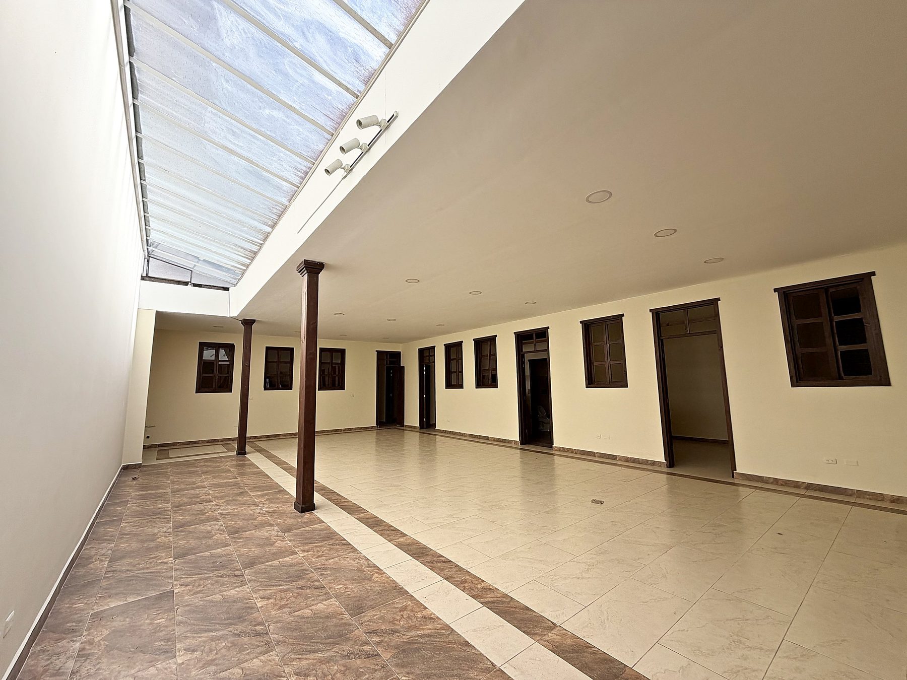 Salón central visto bajo la marquesina de vidrio, con columnas de madera y las puertas de las oficinas al fondo