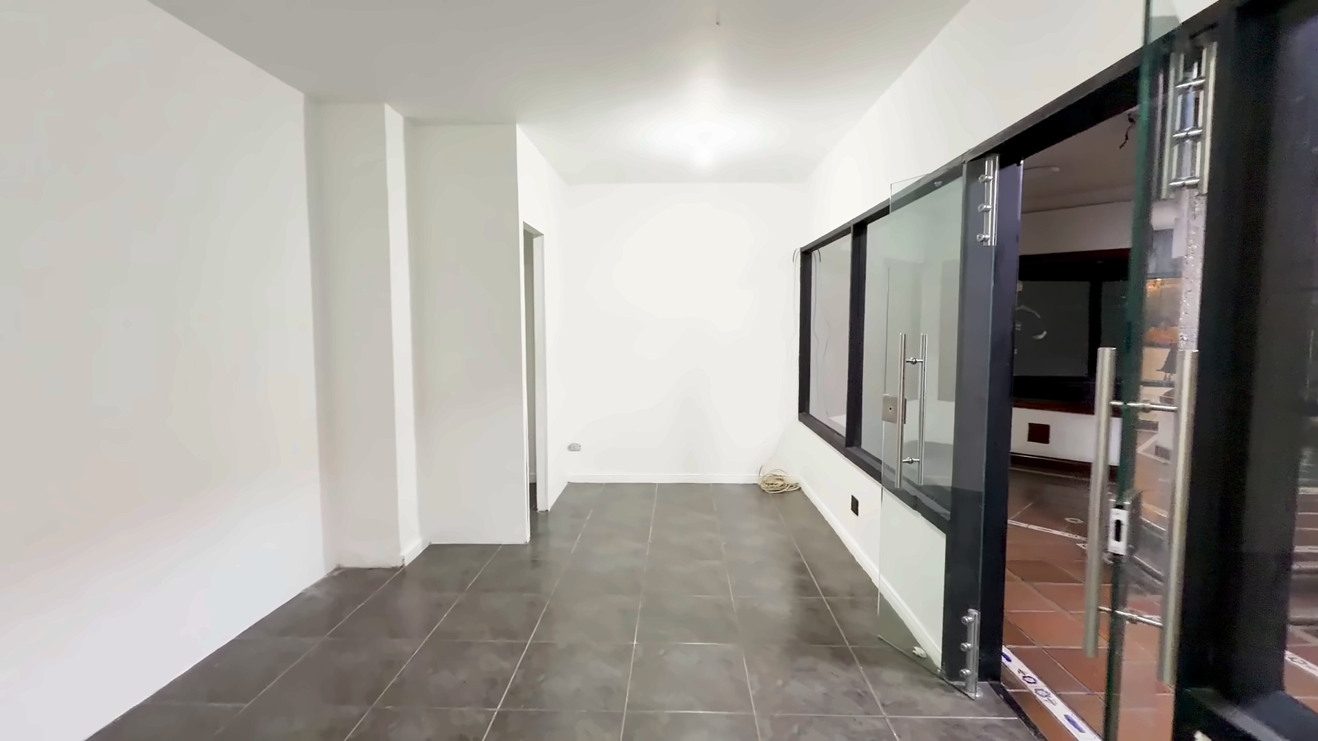 Interior del local con la puerta de vidrio hacia el pasillo