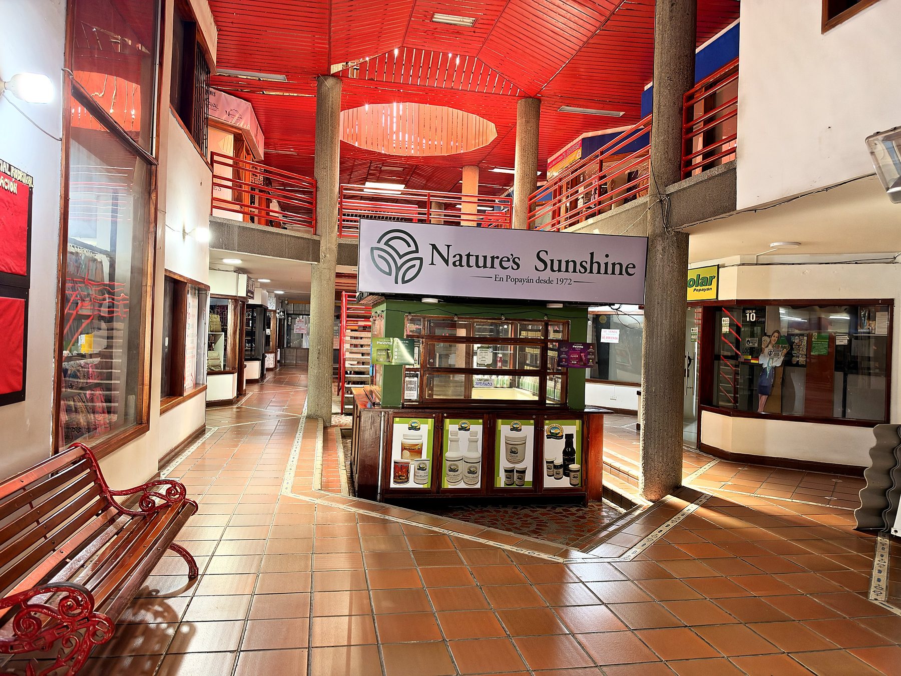 Plazoleta interior del centro comercial con cafés y locales alrededor